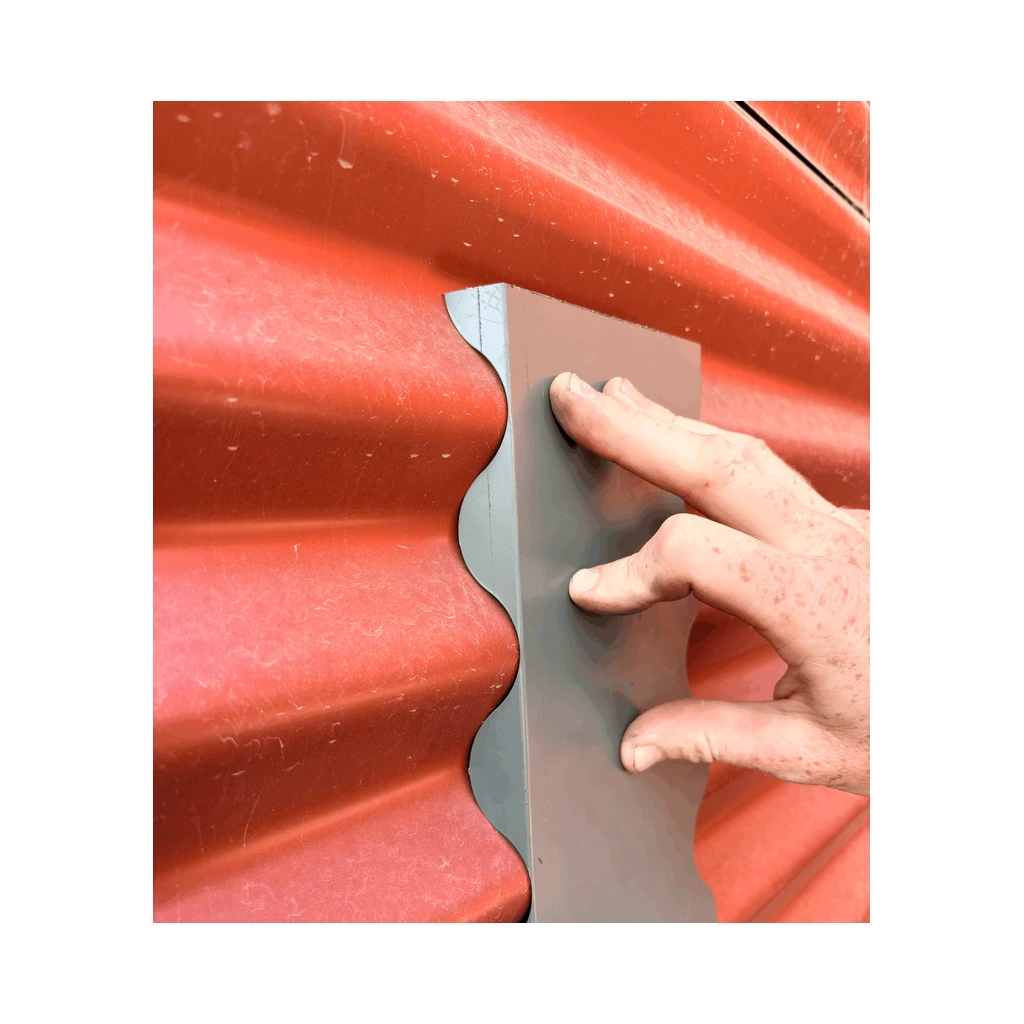 Notched grey flashing fitted against red corrugated cladding