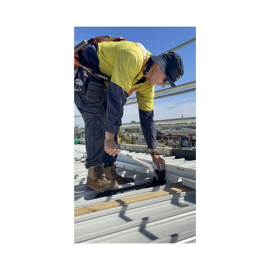 Roofer in hi vis notching a flashing on a Klip-Lok style roof