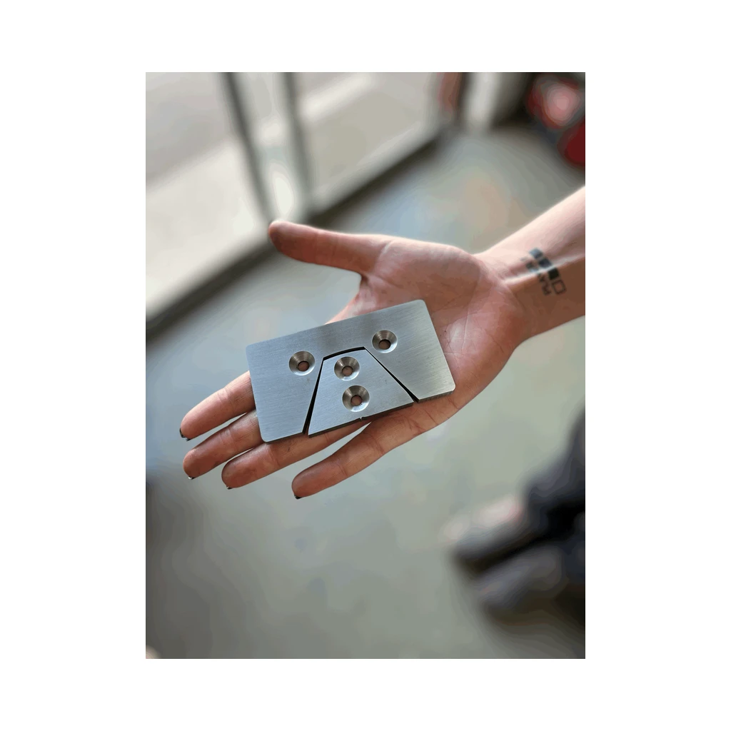 Hand holding an EERA replacement blade set, a flat plate with a trapezoid cut out and its matching insert